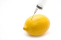 Lemon and syringe on a white background close-up, genetically modified organism. GMO. Vitamins.