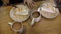 Lemon tart cheese cakes and sweet milk cocoa on table at a cafe. Stock footage. Children at table going to taste