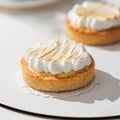 Lemon tartlets with meringue on a light background. With copy space