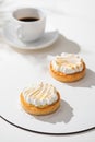 Lemon tartlets with meringue on white and Cup on a light background. With copy space