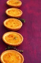 Lemon tartlets with thyme on fuchsia color background