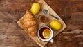 Lemon tea, home made jam, croissant on wooden table. Breakfast concept. Royalty Free Stock Photo