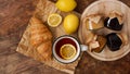 Lemon tea, home made jam, croissant on wooden table. Breakfast concept. Royalty Free Stock Photo