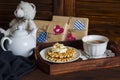 Lemon tea, waffles with ice cream, honey and nuts in a vintage tray, homemade Valentine's day gifts in kraft paper