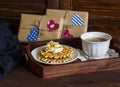 Lemon tea, waffles with ice cream, honey and nuts in a vintage tray, homemade Valentine's day gifts in kraft paper