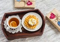 Lemon tea, waffles with ice cream, honey and nuts in a vintage tray, homemade Valentine's day gifts in kraft paper