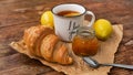 Lemon tea, home made jam, croissant on wooden table. Breakfast concept. Royalty Free Stock Photo