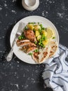 Lemon thyme baked chicken, potatoes and green peas on a white plate on a dark background. Royalty Free Stock Photo