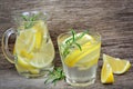 Lemon Water With Rosemary And Ice Cubes In A Glass And Pitcher