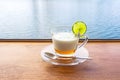 Lemon yogurt fresh milk in a clear glass placed on a brown wooden table with sea water surface background Royalty Free Stock Photo