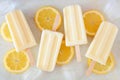 Lemon yogurt popsicles scattered on white marble