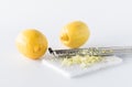 Lemon zest with a microplane and two lemons in behind. Royalty Free Stock Photo