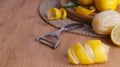 Lemon zest. Rind, fresh fruits and peeler on wooden table, space for text Royalty Free Stock Photo