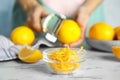 Lemon zest on white marble table and woman with fruits indoors, closeup Royalty Free Stock Photo