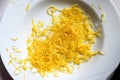 Lemon zest in a white plate, aromatic citrus peel goes well with many dishes and gives a fresh taste, copy space, high angel view