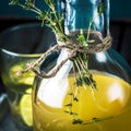 Lemonade in bottle decorated with thyme. Wooden background.