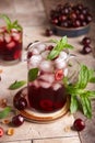 Lemonade with cherries, ice cubes, and mint. Refreshing beverage. Royalty Free Stock Photo