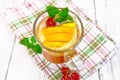 Lemonade with cherry and orange in wineglass on light board