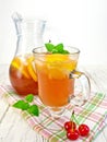 Lemonade with cherry in wineglass and pitcher on board