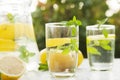 Lemonade close-up on a concrete background with lemons cut open. Whole lemons, mint, fresh summer lemonade in nature, the concept