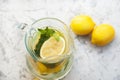 Lemonade close-up on a concrete background with lemons cut open. Whole lemons, mint, fresh summer lemonade in nature, the concept