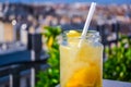 Lemonade cocktail with lemon in glass jar, cold refreshing drink or beverage with ice at a rooftop bar. Royalty Free Stock Photo