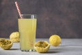 Lemonade or cocktail from passion fruit in tall glass with drinking straw on brown background Royalty Free Stock Photo