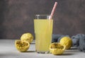 Lemonade or cocktail from passion fruit in tall glass with drinking straw on brown background. Horizontal format Royalty Free Stock Photo