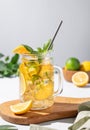 Lemonade drink or cold tea with fresh lemon, mint and ice in a jar. Refreshing citrus mojito cocktail on a wooden board on a Royalty Free Stock Photo