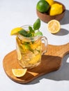 Lemonade drink or cold tea with fresh lemon, mint and ice in a jar. Refreshing citrus mojito cocktail on a wooden board on a Royalty Free Stock Photo