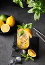 Lemonade drink with fresh lemon, lime, mint and ice. Refreshing citrus mojito cocktail on a dark background. Homemade healthy and Royalty Free Stock Photo