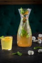 Lemonade drink of soda water, lemon and mint leaves in jar and glass on the black background Royalty Free Stock Photo