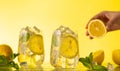 Lemonade with fresh slice lemon and mint leaves. Woman holding half of lemon. Summer homemade drink Royalty Free Stock Photo