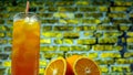 Lemonade with ice in a glass on the background of a brick wall. Orange juice with a transparent glass Royalty Free Stock Photo