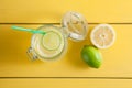 Lemonade with ice, lemon and lime in a jar on a yellow wooden ba Royalty Free Stock Photo