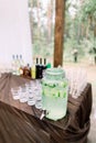 Lemonade jar and glasses for alcohol drinks on wooden table outdoors. Rustic catering at wedding reception. Barn wedding Royalty Free Stock Photo