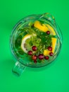 Lemonade juice with lime, lemon, mint leaves, cranberries. Fresh summer ice drink, detox water, ice cubes and glass pitcher Royalty Free Stock Photo