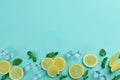 Lemonade layout with juicy lemon slices, mint and ice cubes on turquoise background, top view. Space for text Royalty Free Stock Photo