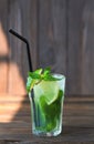 Lemonade with lime, mint on a wooden table. Summer drink