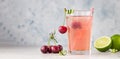 Lemonade or non-alcohol cocktail with cherry and lime in glass on grey stone background. Summer berry drink. Copy space Royalty Free Stock Photo