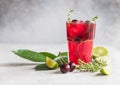 Lemonade or non-alcohol cocktail with cherry and lime, grey concrete background. Summer refreshment drink Royalty Free Stock Photo