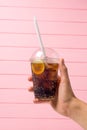 Lemonade in plastic glass with fruit in hand