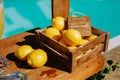 Lemonade table with a box of lemons, silver trays and decanters of lemonade on the edge of the pool with a turquoise water Royalty Free Stock Photo