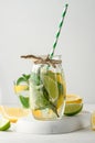 Lemonade in a transparent glass with lemon, lime, rosemary sprigs and mint leaves on a white background Royalty Free Stock Photo