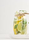 Lemonade in a transparent glass with lemon, lime, rosemary sprigs and mint leaves on a white background Royalty Free Stock Photo