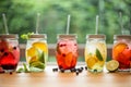 Lemonades on summer spring terrace table with organic fruits on leaf bokeh