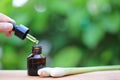 Lemongrass essential oil dropping to glass bottles on natural green background, Insect repellent