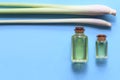 Lemongrass essential oil in glass bottles on blue background Royalty Free Stock Photo