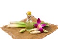 Lemongrass oil in clear bottles, orchid flowers, placed on a sack. Royalty Free Stock Photo