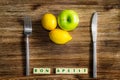 Lemons and apple on wooden vintage table with silverware